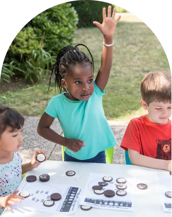 Three year old at summer camp engaged in science activity